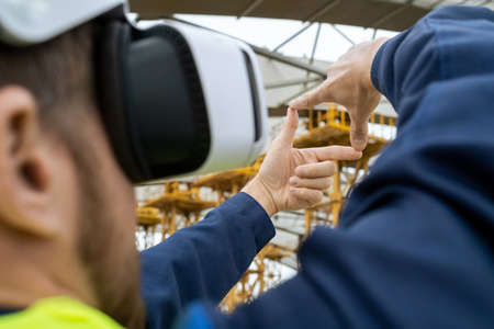 Hands of builder in vr headset making frame in front of himselfの写真素材