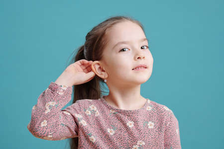 Cute little girl showing new earrings on earの写真素材