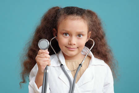 Adorable little doctor with stethoscope examining patientの写真素材