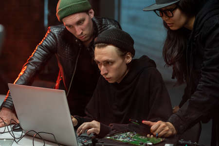 Group of intercultural hackers committing information crimeの写真素材
