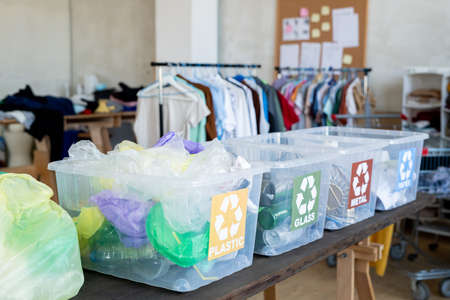 Four plastic containers with sorted waste on table