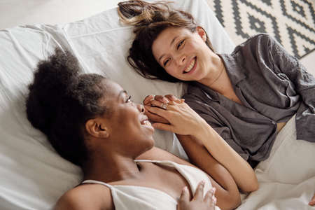 Smiling young woman looking at her girlfriend of African ethnicityの写真素材