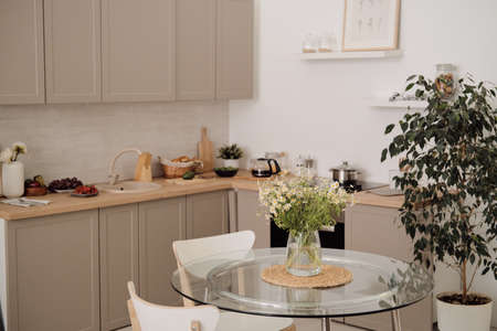 Interior of modern kitchen with chairs around table in the centerの写真素材