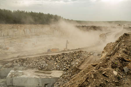 Vast quarry or construction site with long road in the center against natural environmentの写真素材