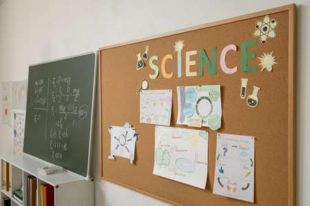 Two blackboards with physical formulas and papers with project points inside classroom