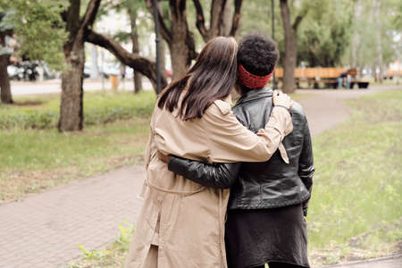 Rear view of two young multiracial women in casualwear taking walk in parkの写真素材