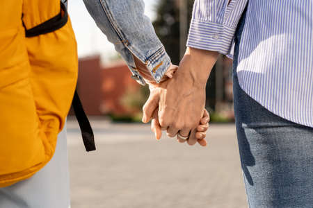 Hands of mother and daughter in casualwear going to school in the morningの写真素材