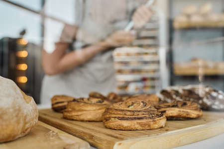 Close-up of fresh baked pastry assortment on wooden boards presented on displayの写真素材