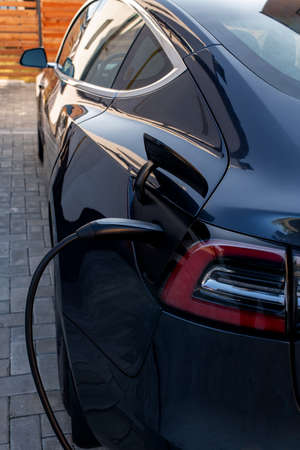 Back part of black electric car during charge at contemporary stationの写真素材