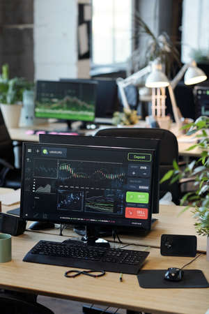 Computer monitor with graphic online information standing on deskの写真素材