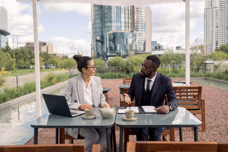 Two intercultural business partners discussing terms of contract before signing itの写真素材