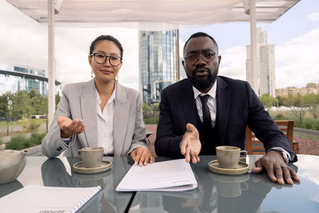 Two intercultural brokers interacting with their business partner during video call
