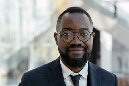 Young smiling man in eyeglasses and elegant suit looking at you in trade centerの写真素材