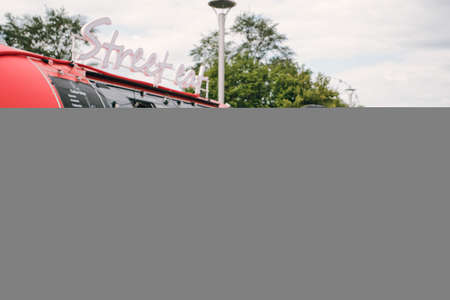 Young female owner of street food truck standing in front of camera outdoorsの写真素材