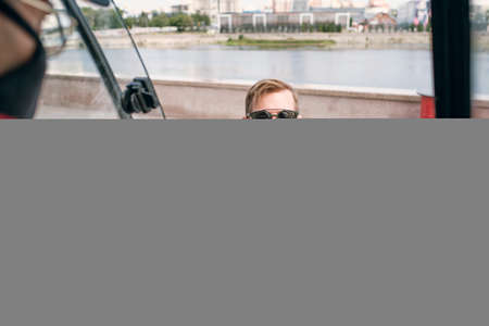 Young man in sunglasses and casualwear paying for fast food by contactless payment systemの写真素材