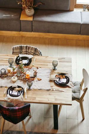 High angle view of beautiful dining table decorated with autumn branches in the room