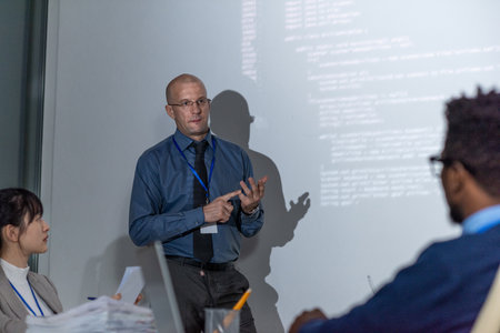 Experienced it-developer in formalwear explaining new way of decoding data to audience during...