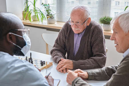 Elderly man listening the recommendation of doctor during their conversation at the tableの写真素材