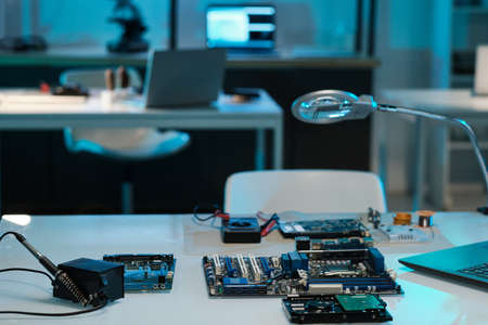 Workplace of engineer or technician with motherboard or circuit board, soldering iron and magnifying glassの写真素材