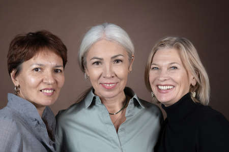 Portrait of beautiful mature women smiling at camera isolated on grey backgroundの写真素材