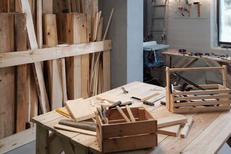 Background image of carpentry workshop with focus on wooden tool boxes in foreground, copy spaceの写真素材