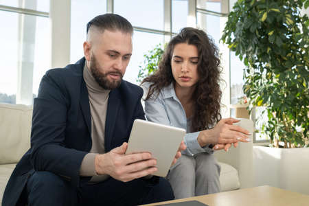 Confident middle aged ceo of high tech corporation explaining data to young female subordinate...