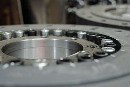 Macro shot of huge round detail or spare part for industrial or construction machine made up of...