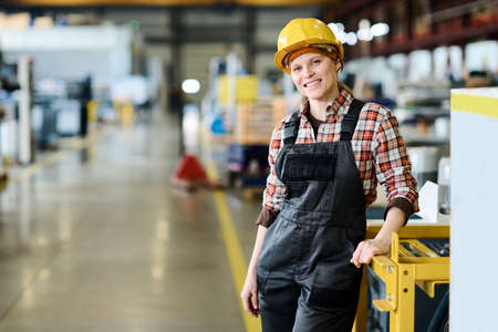 Successful technical inspector or manager of large factory looking at camera with smile while...