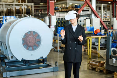 Young busineswoman in black formalwear and vr headset making presentation of new virtual product...
