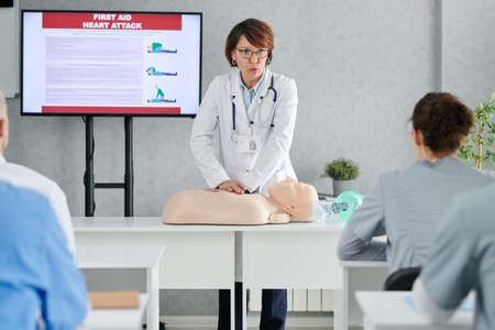 Medical specialist demonstrating on mannequin how to providing first aid to students at trainingの写真素材