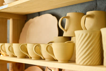 Part of display consisting of several wooden shelves with handmade earthenware such as cups, mugs...
