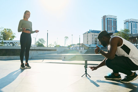 Young African American sportsman pointing at smartphone screen before shooting video of sports...