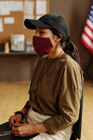 Young stressed Hispanic woman in protective mask describing her psychological problems caused by post traumatic syndromeの写真素材
