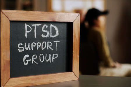 Small chalkboard with name of psychological support group or course in wooden frame standing against attendants of sessionの写真素材