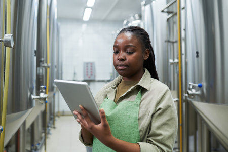 Brewery worker managing fermentation process via application on tablt computerの写真素材