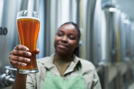 Worker holding big glass of beer produced in small breweryの写真素材