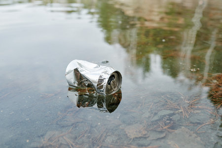 Aluminum can in water, polluted lake concept