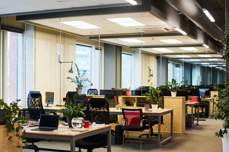 Part of spacious contemporary office in business center with long aisle along coworking area with...