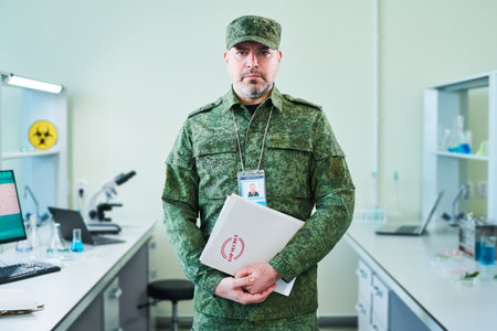 Serious mature officer in military uniform holding folder with secret files describing laboratory...