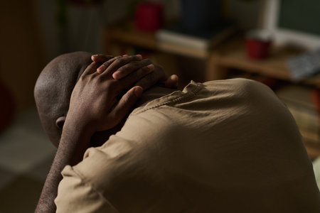 African American depressed man having problems, he sitting alone in his room