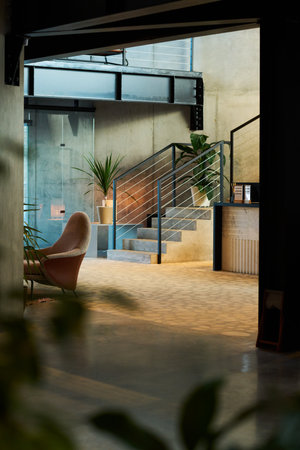 Selective focus on part of lounge with armchair against small staircase decorated with green...