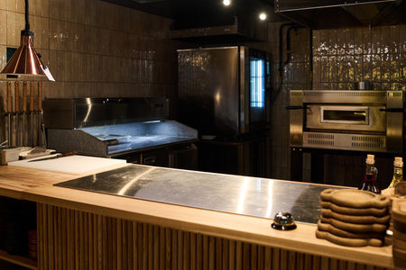 Interior of spacious kitchen of cafe, pizzeria or luxurious restaurant with large table with...