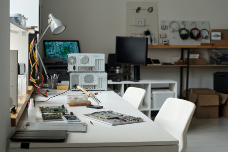 Disassembled laptop on workplace of technician of repair service center in spacious office or modern...