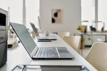 No people selective focus shot of part of modern office interior with laptops on table, copy spaceの写真素材