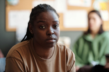 Face of young stressed woman with post traumatic syndrome looking at camera with sad expression...