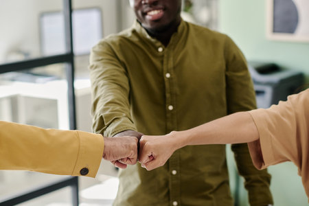 Group of colleagues greeting each other with handshakes in modern office environment, showcasing...