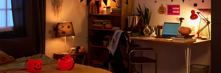 Panorama of poorly lit interior of child bedroom decorated for celebrating Halloween with two trick-or-treat buckets on bedの写真素材