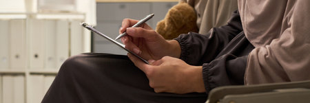 Person using stylus on tablet in modern office environment, focusing on technology for note-taking....