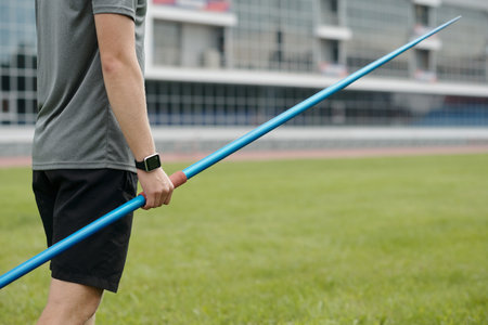 Athlete holding javelin on sports field preparing for a throw at stadium. Image capturing focus, strength, and determination of track and field sportの写真素材