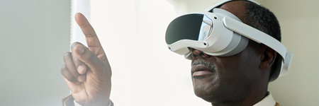 Banner of aged African American businessman with virtual reality headset pointing at augmented...